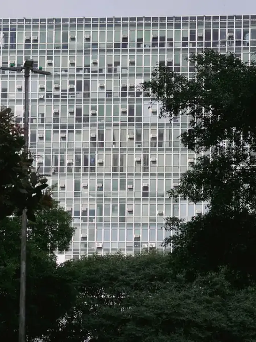 A residential building behind trees in São Paulo